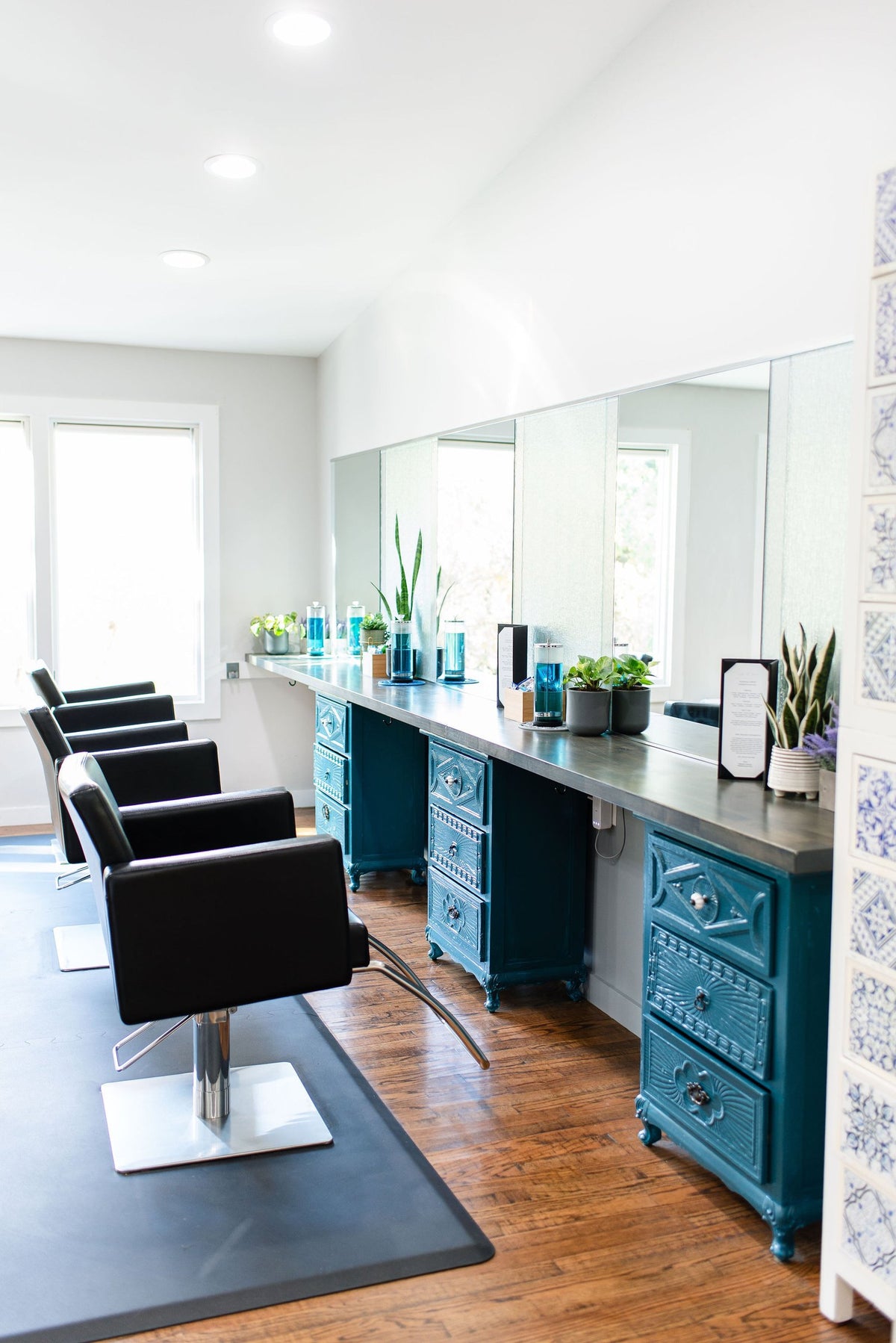 Row of styling chairs and teal stations at Elevate Salon + Spa, Charlottesville VA
