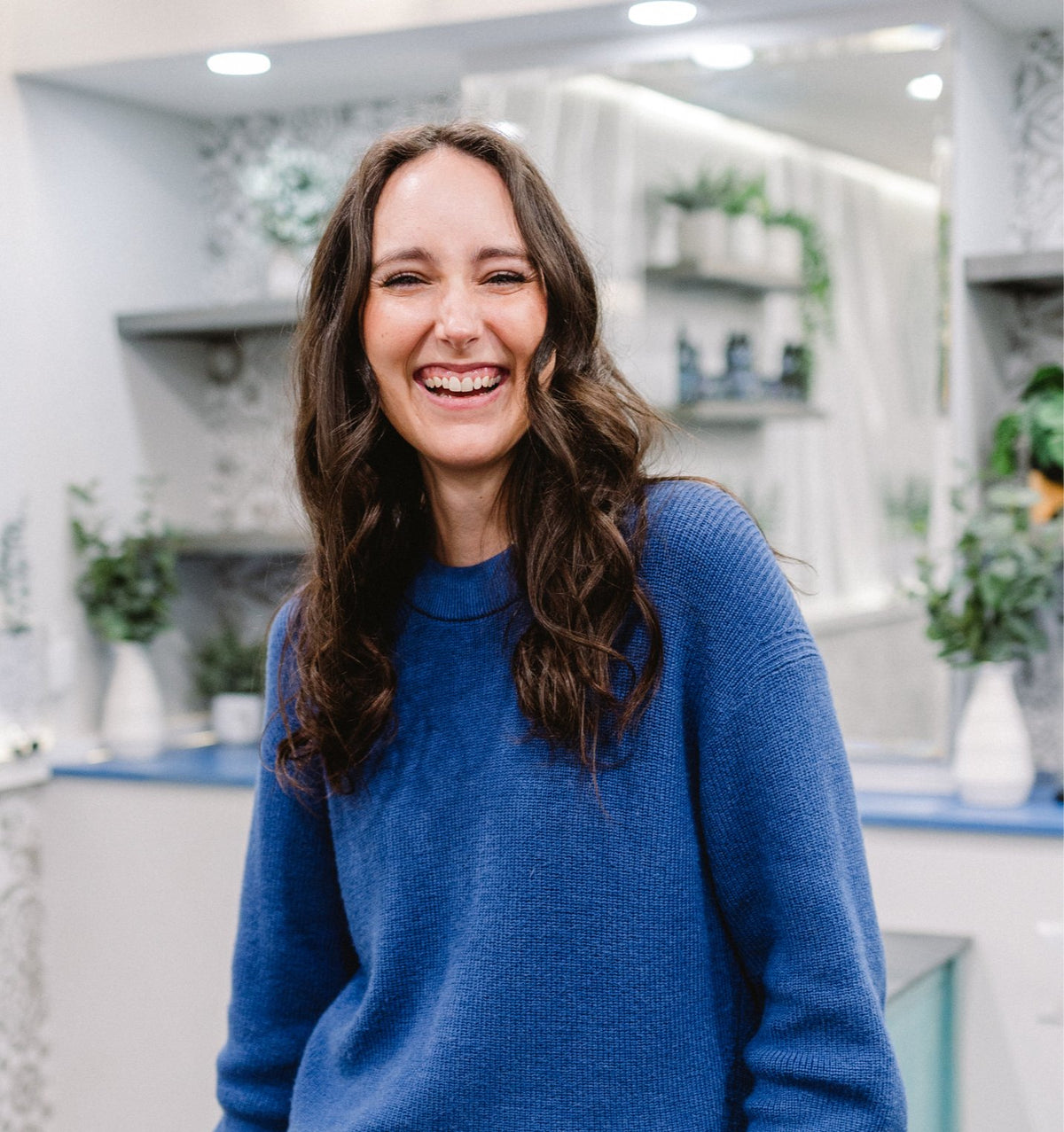 Smiling guest with long brunette waves at Elevate Salon + Spa, Charlottesville VA