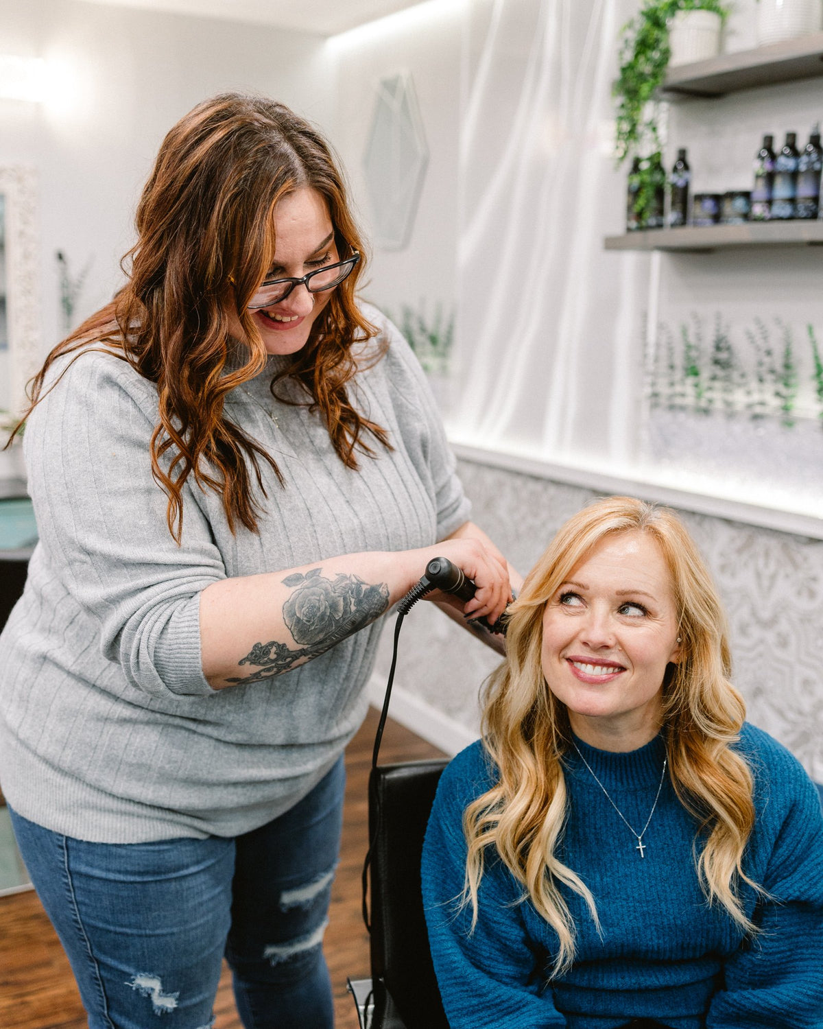 Stylist curling a guest's hair at Elevate Salon + Spa, Charlottesville VA